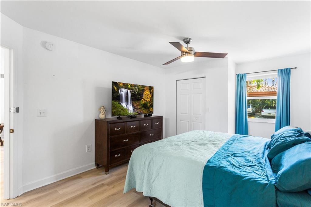 Bedroom featuring light wood finished floors, a closet, and a ceiling fan