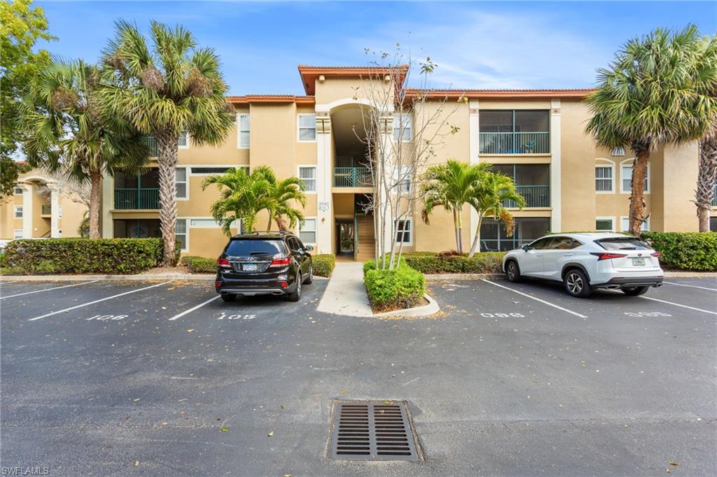 View of apartment building / complex with uncovered parking