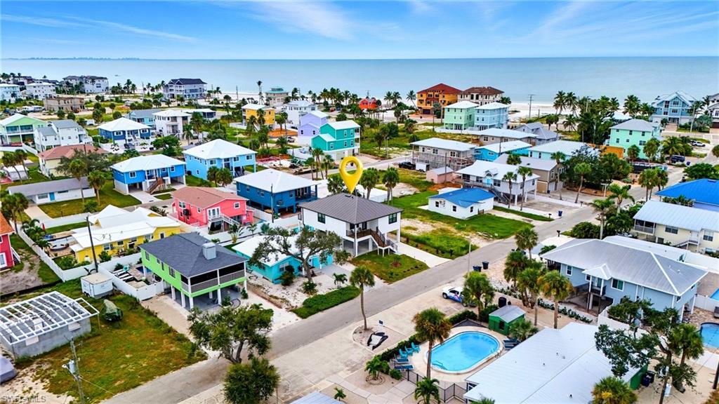 Aerial view of residential area featuring a pool area and a large body of water - Virtually Edited Image