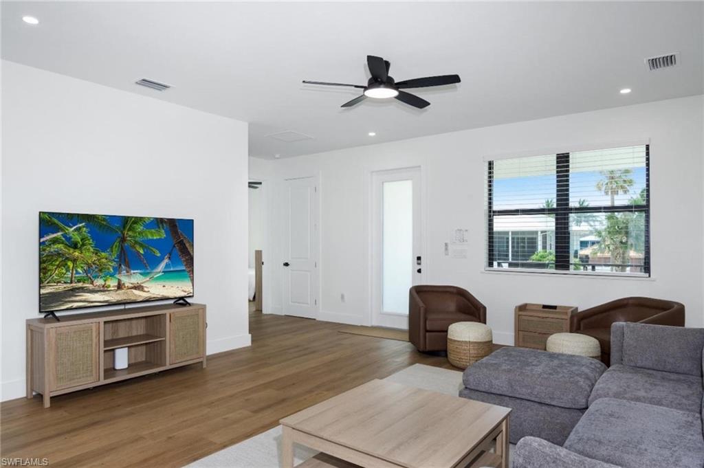 Living area with recessed lighting, wood finished floors, and ceiling fan - Virtually Edited Image