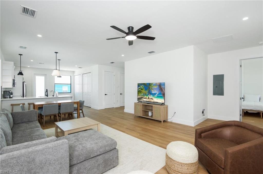 Living area with recessed lighting, light wood-type flooring, electric panel, and ceiling fan - Virtually Edited Image