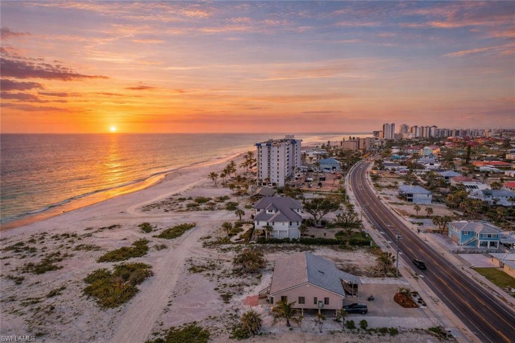 Aerial view at dusk of view of water and beach and a view of city