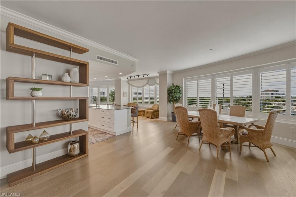 Dining room with crown molding and light wood-type flooring