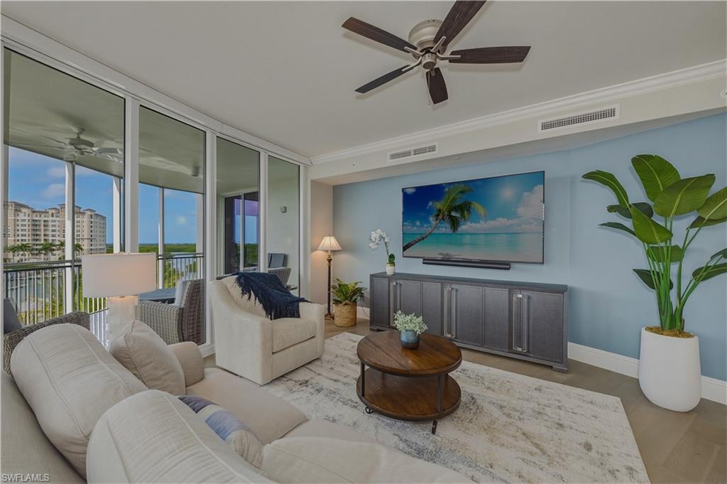 Living room featuring a ceiling fan, floor to ceiling windows, wood finished floors, and ornamental molding