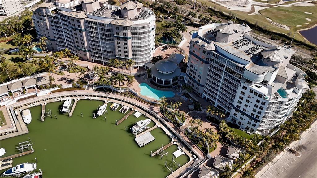 Aerial view of property and surrounding area featuring a nearby body of water and apartment complex