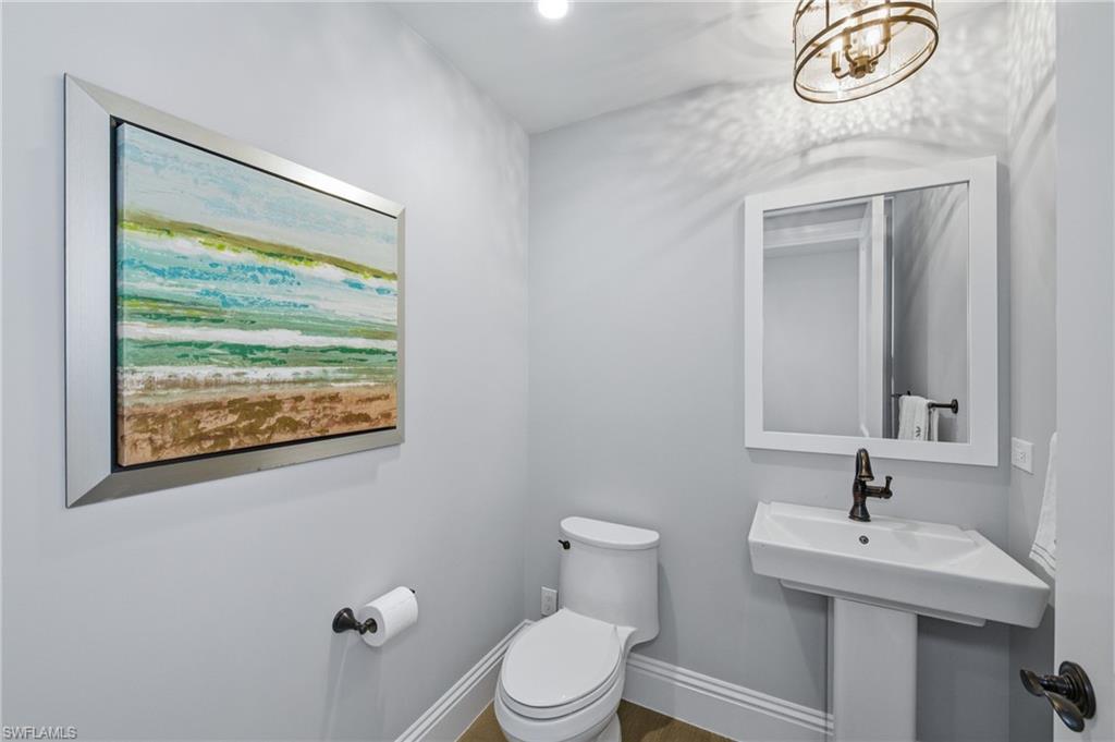 Half bath with hanging lights and wood finished floors