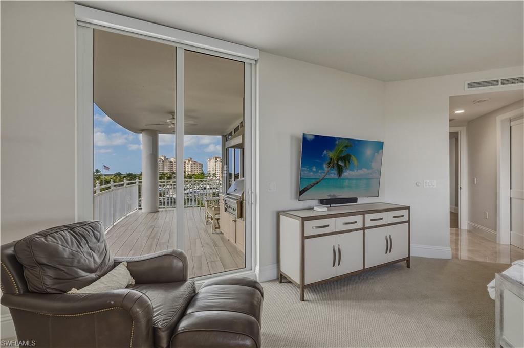 Living area with light carpet, floor to ceiling windows, and ceiling fan