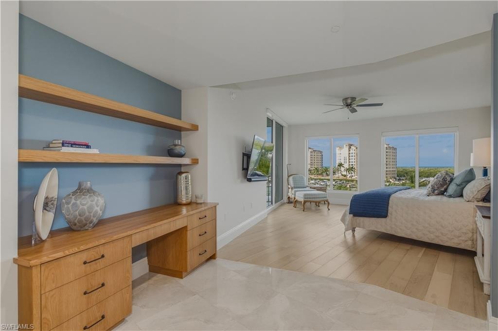 Bedroom with light wood-type flooring, access to outside, built in desk, and a ceiling fan