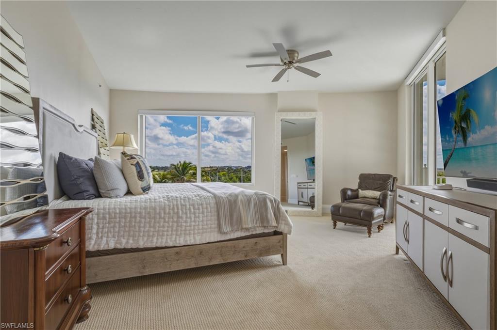 Bedroom with light carpet, ceiling fan, and access to outside