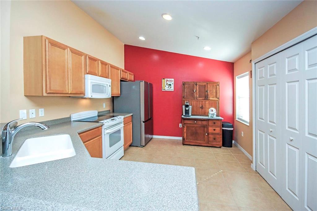 Kitchen featuring white appliances, light countertops, and light tile patterned flooring