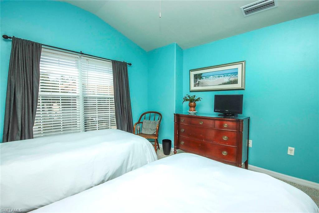 Bedroom with vaulted ceiling and baseboards