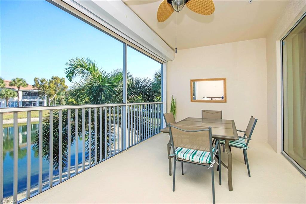 Oversized lanai with ceiling fan, outdoor dining space, and a water view