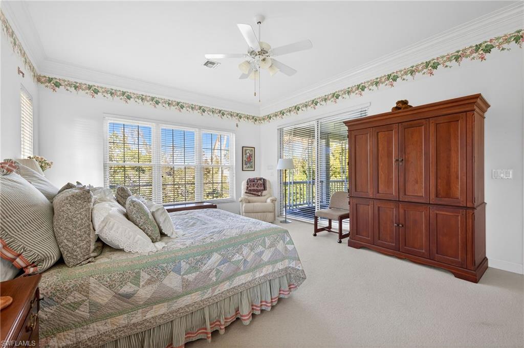 Bedroom featuring light carpet, multiple windows, a ceiling fan, crown molding, and access to exterior