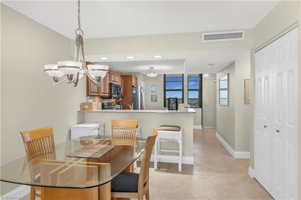 Dining room with light tile patterned flooring and suspended lighting