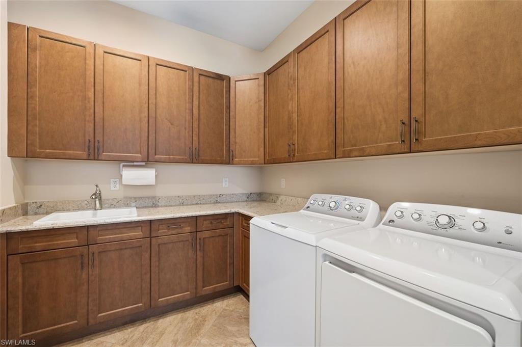 Laundry room with washer and clothes dryer and cabinet space