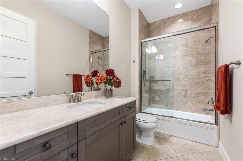 Full bath featuring vanity and combined bath / shower with glass door