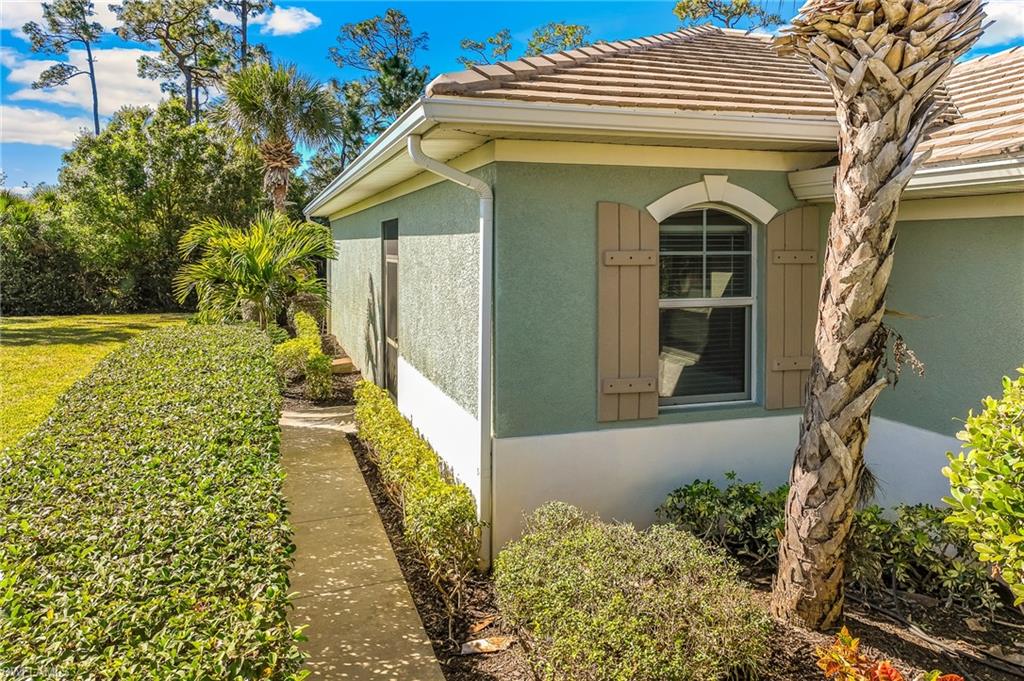 View of side of property with stucco siding and a tile roof