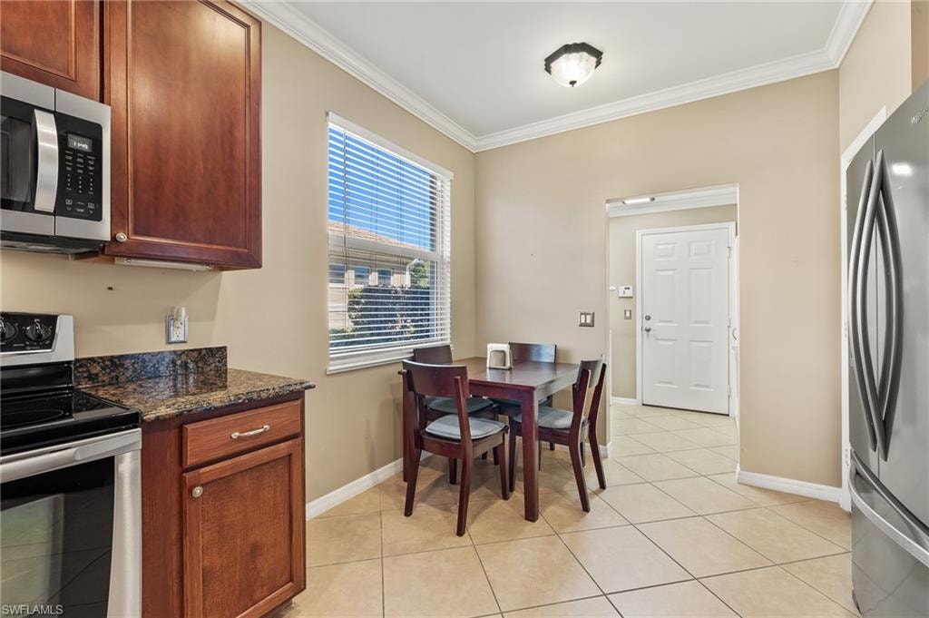 Dining room featuring crown molding and light tile patterned floors