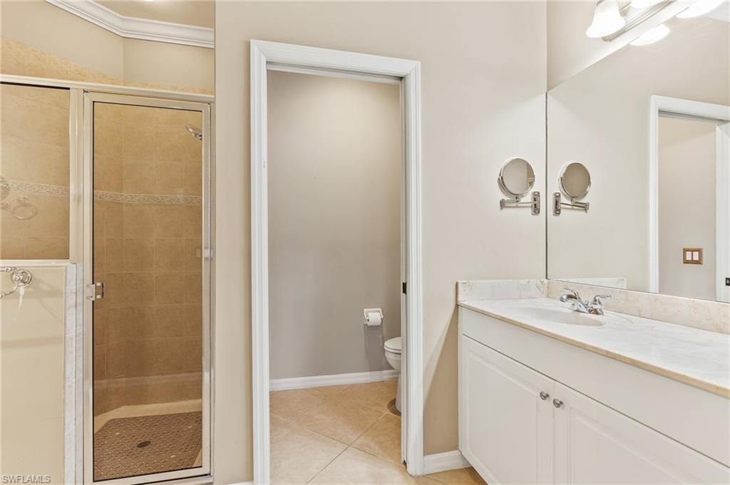 Bathroom with vanity, a stall shower, and light tile patterned floors