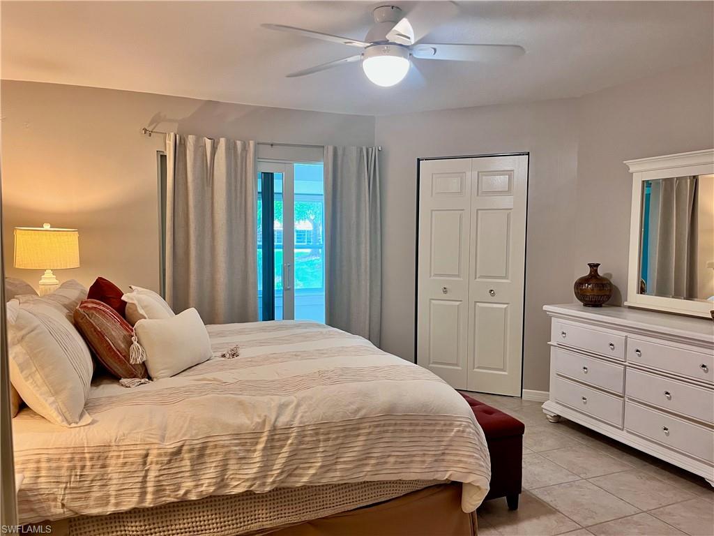 Bedroom featuring light tile patterned floors, a ceiling fan, and a closet