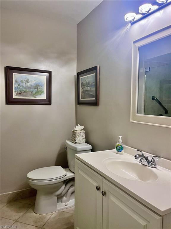 Full bathroom featuring single vanity, tile floors, and a shower