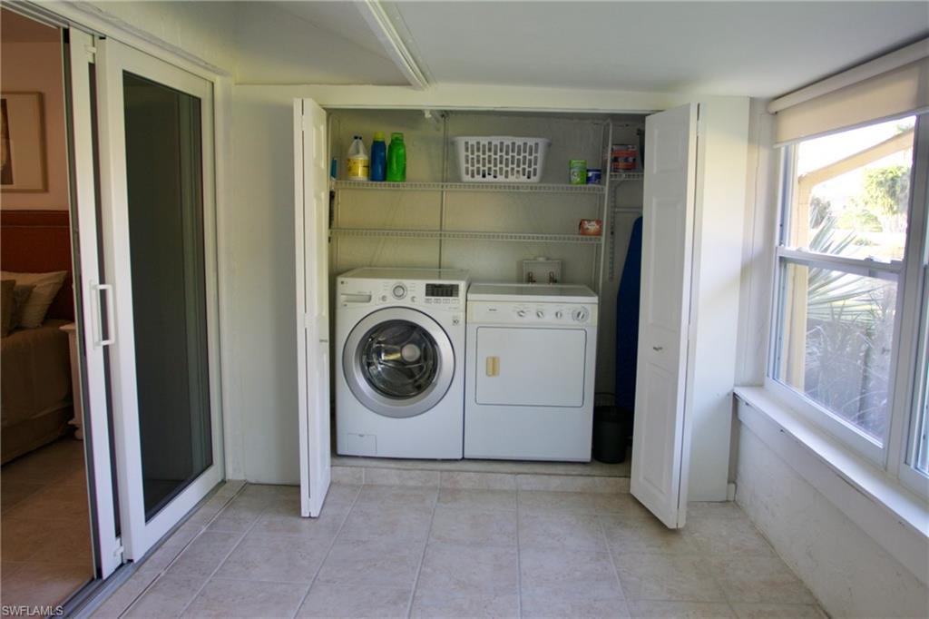 Clothes washing area with washing machine and clothes dryer and light tile patterned floors
