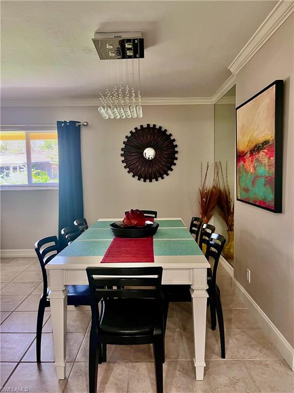 Dining area featuring ornamental molding and light tile flooring
