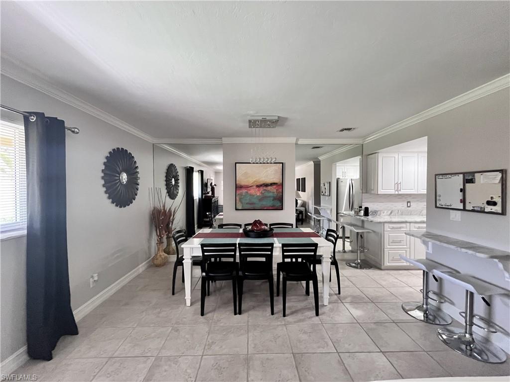 Dining room featuring ornamental molding and light tile floors