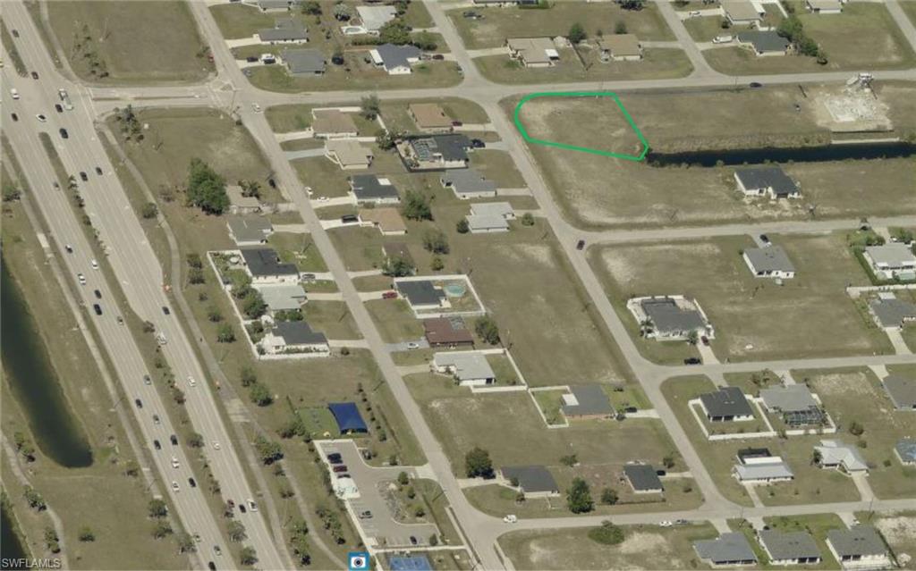 Aerial view of property and surrounding area featuring property parcel outlined