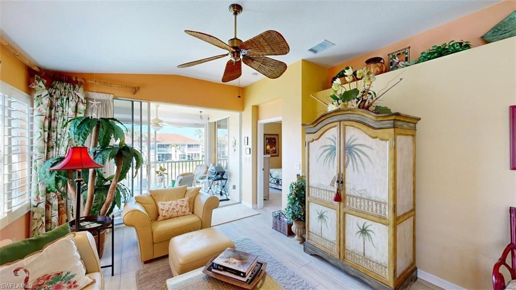 Living area featuring ceiling fan, wood finished floors, and vaulted ceiling