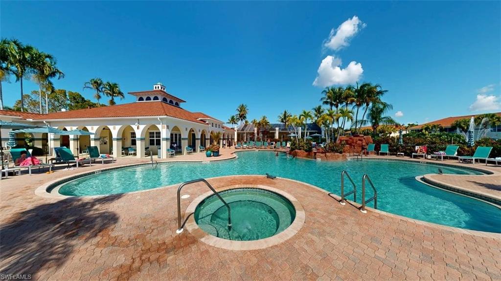 Community pool with a patio area and a hot tub