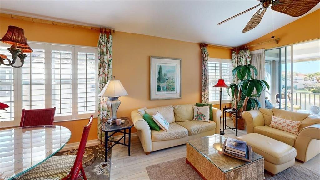 Living area featuring lofted ceiling, wood finished floors, and ceiling fan