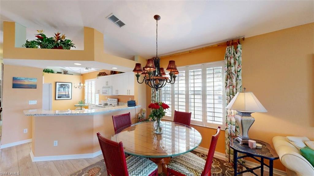 Dining area featuring plenty of natural light, hanging lights, and light wood finished floors