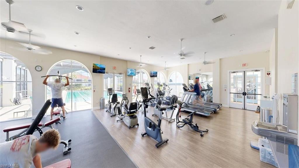 Workout area featuring a ceiling fan and french doors