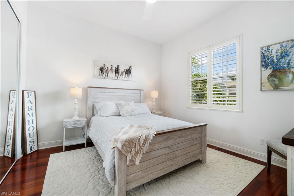 Bedroom with dark wood finished floors, a closet, and a ceiling fan