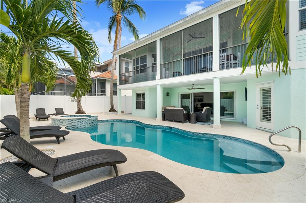Integrated pool / spa featuring a patio, a balcony, outdoor lounge area, a fenced backyard, and a sunroom