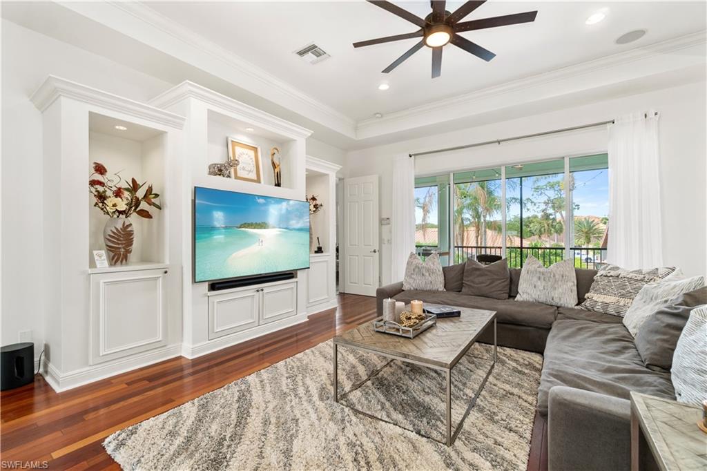Living room with dark wood-style flooring, a ceiling fan, ornamental molding, and recessed lighting