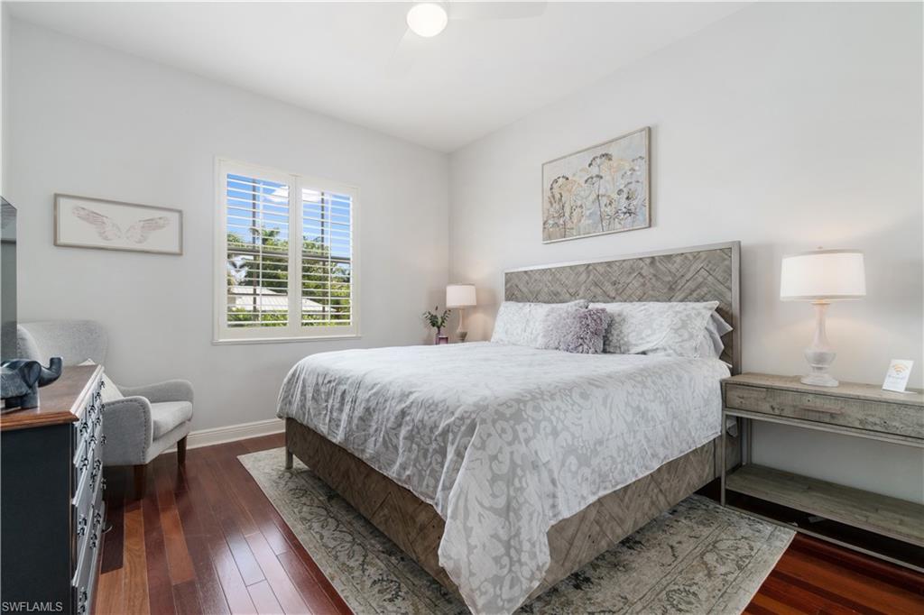 Bedroom with dark wood-type flooring and a ceiling fan
