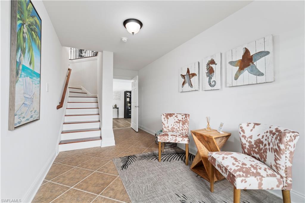 Sitting room featuring stairway and light tile patterned floors