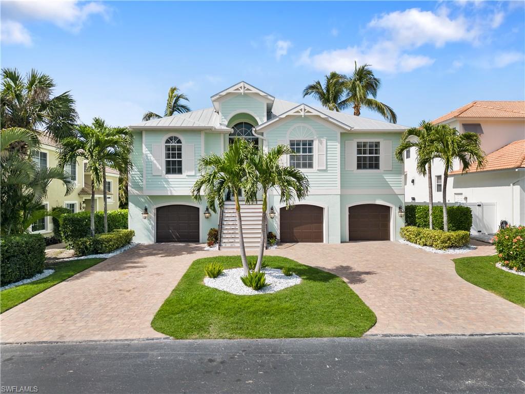 Raised beach house with a garage and driveway
