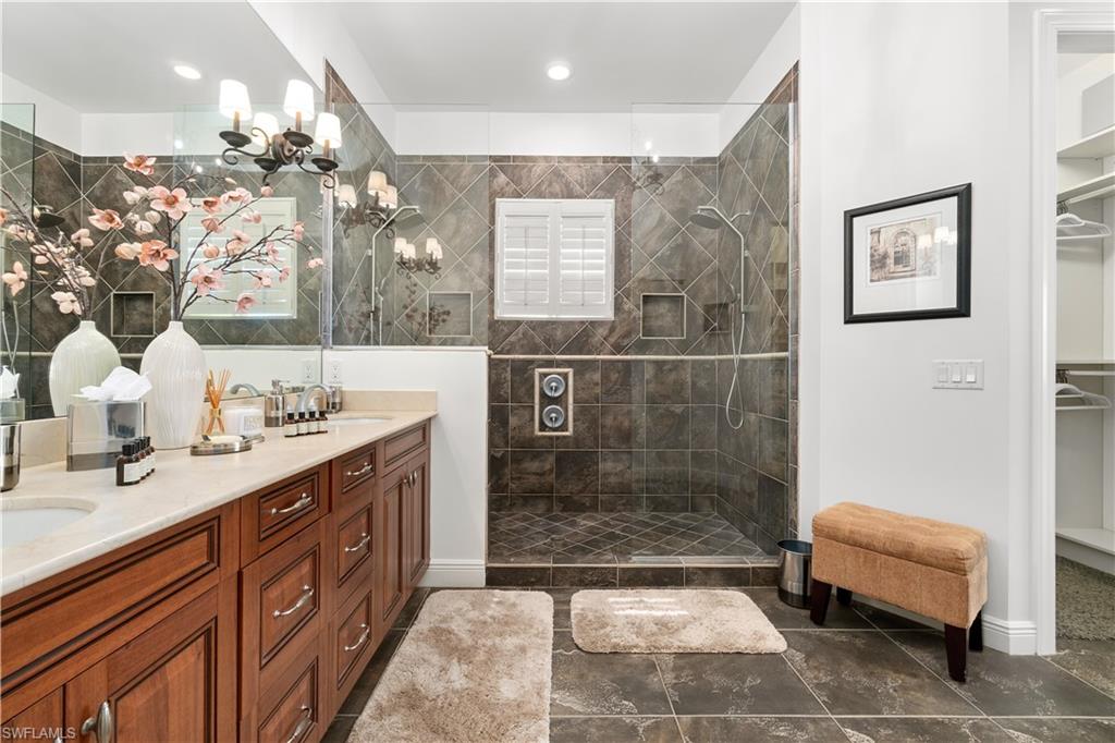 Bathroom featuring double vanity, a walk in closet, and walk in shower