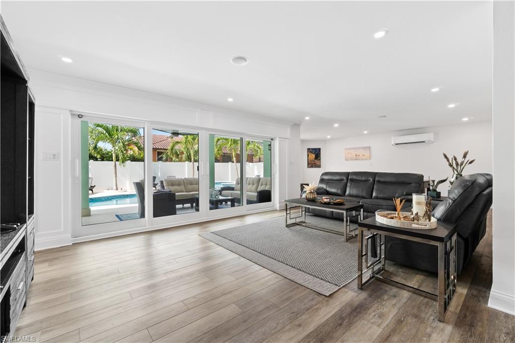 Living room featuring plenty of natural light, light wood finished floors, and recessed lighting