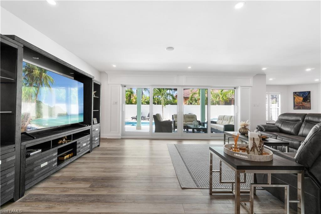Living room with light wood finished floors, healthy amount of natural light, and recessed lighting