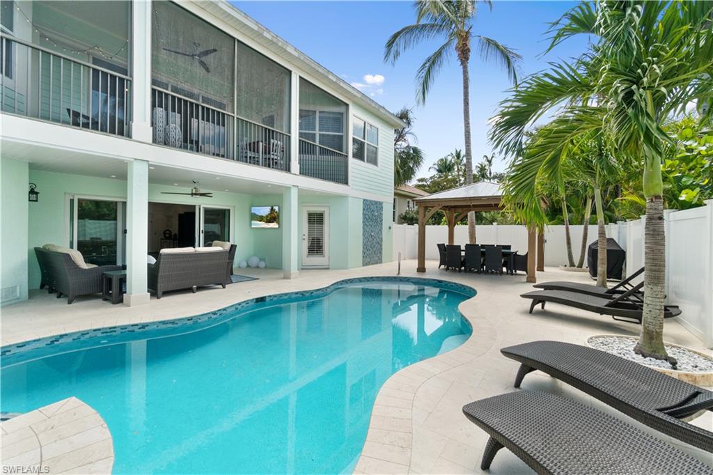 View of pool with patio surround, outdoor lounge area, a balcony, and a fenced backyard
