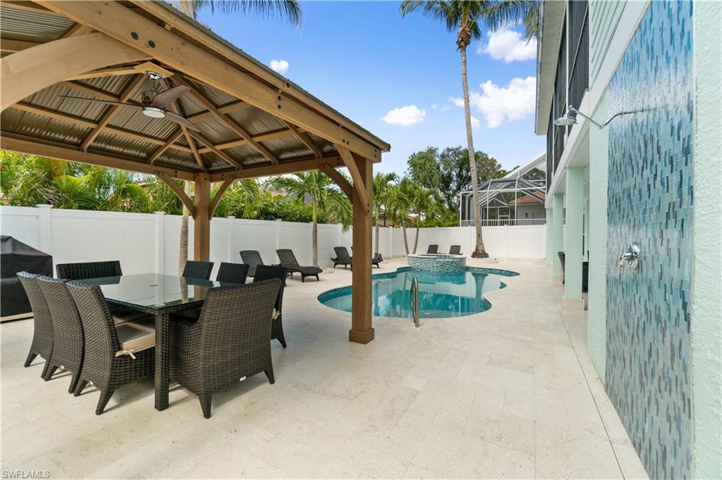 Integrated pool / spa with a patio, a gazebo, outdoor dining area, area for grilling, and a fenced backyard