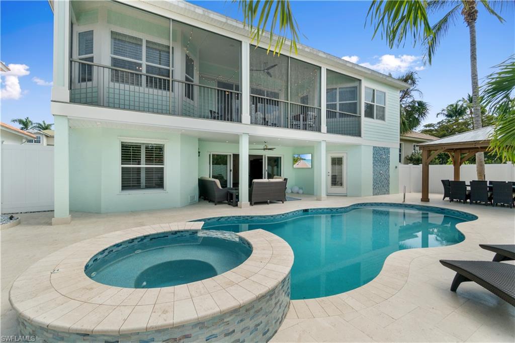 Rear view of property featuring a patio area, a ceiling fan, a balcony, and stucco siding