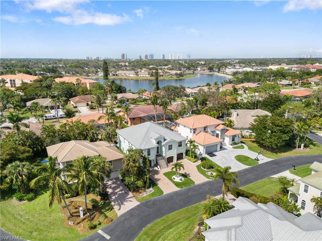 Aerial perspective of suburban area featuring a large body of water and city skyline