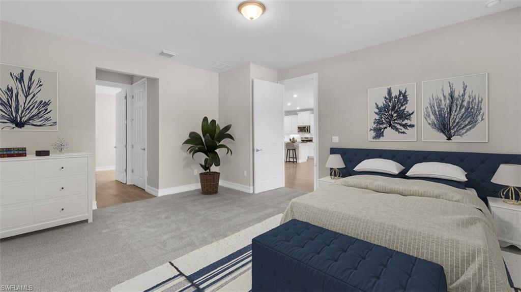 This image is virtually staged. Bedroom featuring light colored carpet and baseboards