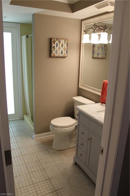Bathroom with a shower stall, vanity, and light tile patterned flooring