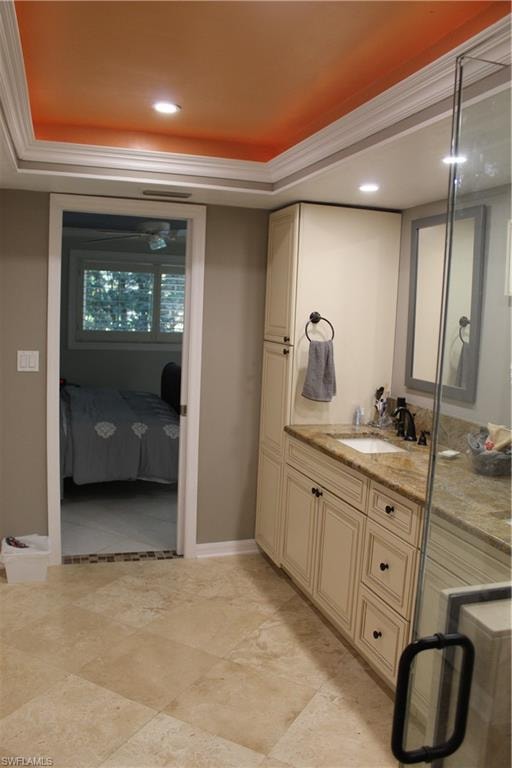 Full bath with ensuite bathroom, vanity, recessed lighting, a tray ceiling, and ornamental molding
